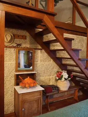 a room with a staircase with a table and a mirror at Casa AsCampinas in Ourense