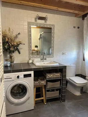 a bathroom with a sink and a washing machine at Casa AsCampinas in Ourense