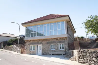 a house with a lot of windows on a street at PENSION BOUTIQUE TEIXEIRA, 3 ESTRELLAS in La Teijeira