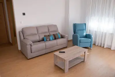 a living room with a couch and a blue chair at PENSION BOUTIQUE TEIXEIRA, 3 ESTRELLAS in La Teijeira