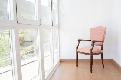 a chair sitting in a room next to a window at PENSION BOUTIQUE TEIXEIRA, 3 ESTRELLAS in La Teijeira