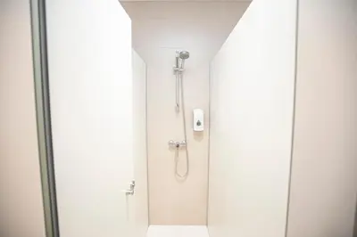 a shower in a bathroom with a glass door at Albergue A Fabrica in Santiago de Compostela