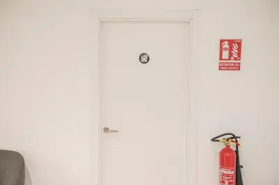 a white door with a fire hydrant next to it at Albergue A Fabrica in Santiago de Compostela