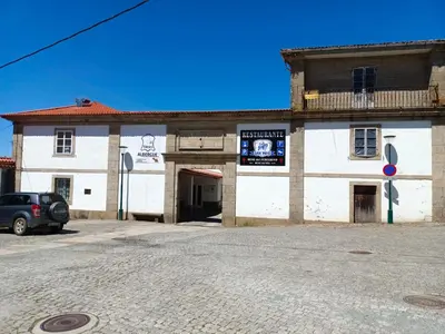 a building with a car parked in front of it at Albergue A Fabrica in Santiago de Compostela