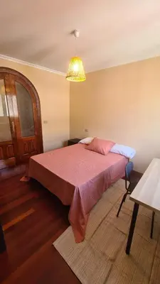a bedroom with a bed with a pink comforter at Montirón Lucus Confort in Lugo