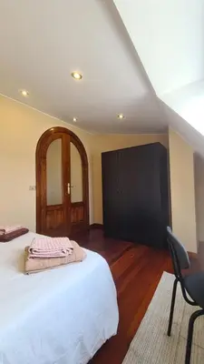 a bedroom with a bed and a chair in it at Montirón Lucus Confort in Lugo
