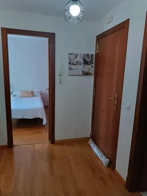 a room with a door and a bedroom with a bed at Recanto Milladoiro in Milladoiro