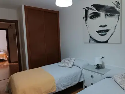 a bedroom with two beds and a picture of a woman at Recanto Milladoiro in Milladoiro