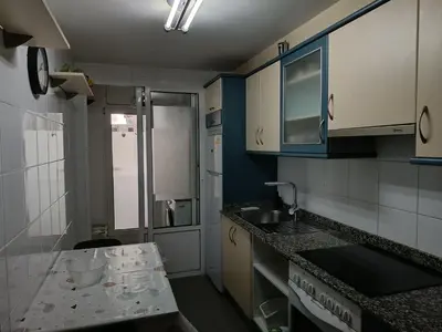 a kitchen with blue and white cabinets and a sink at Recanto Milladoiro in Milladoiro