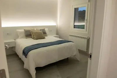 a white bedroom with a bed and a window at Casa Tía Pepa in Castenda