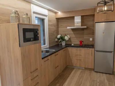 a kitchen with wooden cabinets and a white refrigerator at Casa Tía Pepa in Castenda