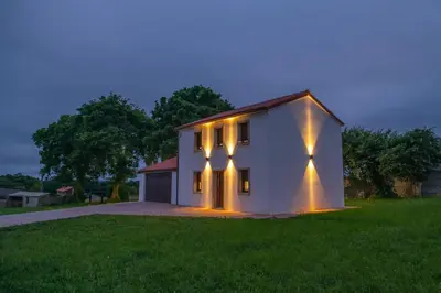 a white house with lights on the side of it at Casa Tía Pepa in Castenda