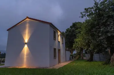 a white house with lights on the side of it at Casa Tía Pepa in Castenda
