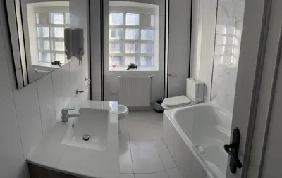 a white bathroom with a sink and a tub and a toilet at Viviendas vacacionales as lagas in Palas de Rei