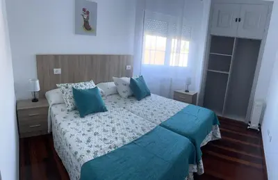 a bedroom with a bed with blue pillows at Viviendas vacacionales as lagas in Palas de Rei