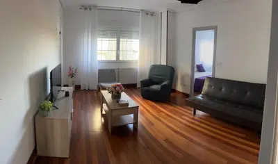 a living room with a black couch and a table at Viviendas vacacionales as lagas in Palas de Rei
