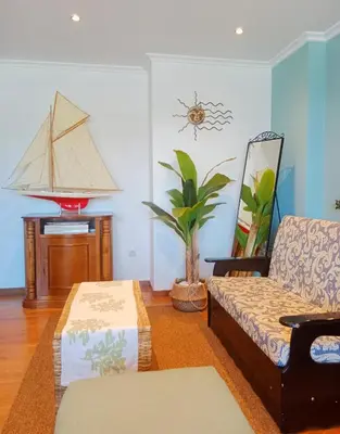a living room with a couch and a boat on the wall at Penthouse Panorámico in Viveiro