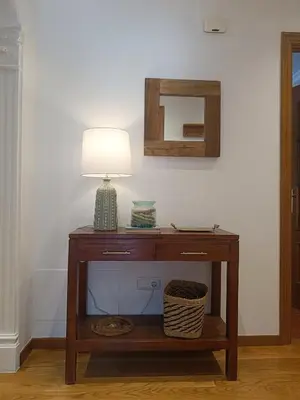 a table with a lamp and a mirror on a wall at Penthouse Panorámico in Viveiro