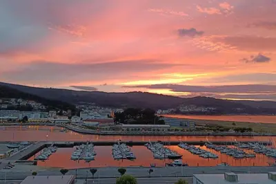 a group of boats in a marina at sunset at Penthouse Panorámico in Viveiro
