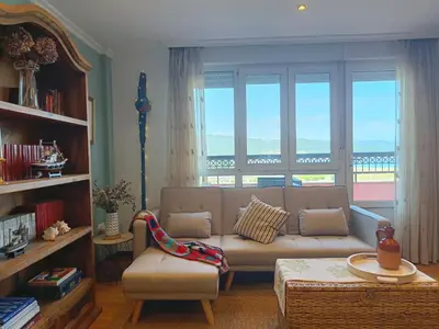 a living room with a couch and a large window at Penthouse Panorámico in Viveiro