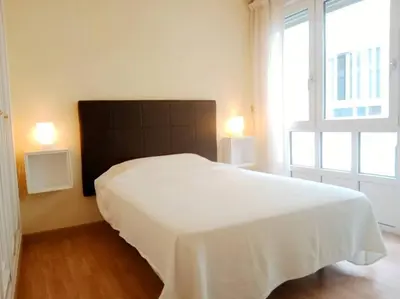 a white bed in a room with a large window at Pastor Diaz Home in Viveiro