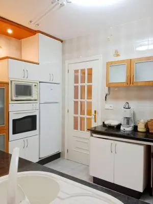 a kitchen with white cabinets and a stove top oven at Pastor Diaz Home in Viveiro