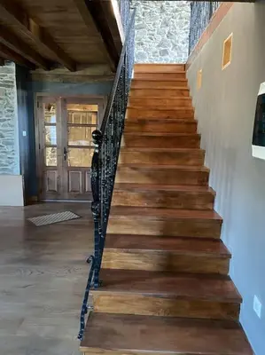 a wooden staircase in a room with a door at Casona Rural de Lujo con increíbles vistas, La Casa de Rafael, ahora con 4 habitaciones in San Antolín