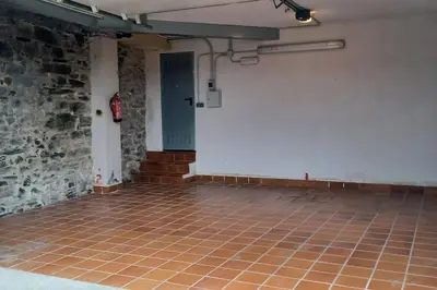 an empty room with a brick wall and a tile floor at Piso con preciosas vistas, patio privado y amplio garaje in Puentedeume