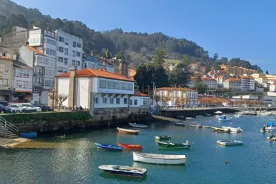a group of boats in a river with buildings at Piso con preciosas vistas, patio privado y amplio garaje in Puentedeume