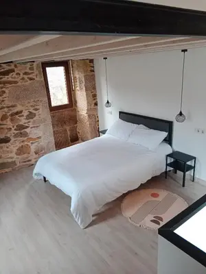 a bedroom with a large white bed with a window at La Gavina in Beáriz