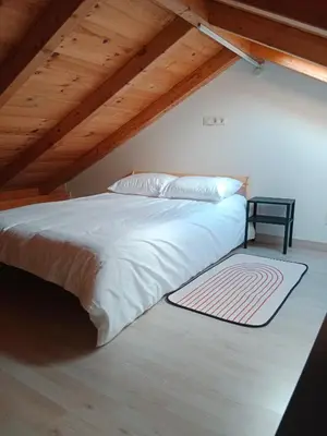 a bedroom with a white bed with a wooden ceiling at La Gavina in Beáriz