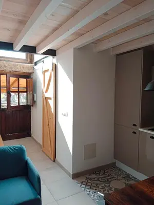 a living room with a blue couch and a kitchen at La Gavina in Beáriz