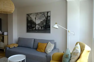 a living room with a blue couch and a lamp at Adarve, con parking y vistas a la muralla in Lugo