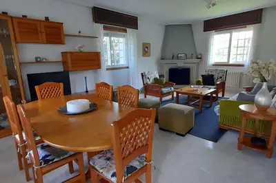 a living room with a wooden table and chairs at Casa rural con piscina en la Ribeira Sacra. in Campos