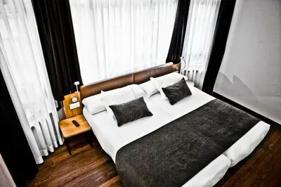 a bedroom with a bed with white sheets and pillows at Hotel Lux Santiago in Santiago de Compostela