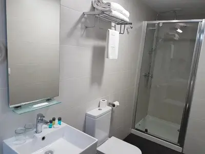 a bathroom with a sink and a shower and a toilet at Hotel Lux Santiago in Santiago de Compostela