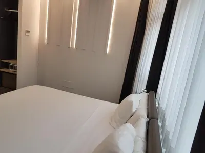 a bedroom with a bed with white sheets and a window at Hotel Lux Santiago in Santiago de Compostela