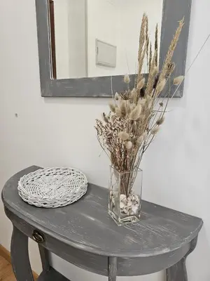 a vase of flowers on a table with a mirror at MEDA Padrón in Padrón