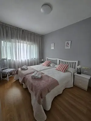 a bedroom with a large bed with two towels on it at MEDA Padrón in Padrón