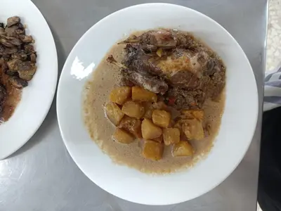 a plate of food with meat and potatoes on a table at COMPLEXO TURISTICO PONTE MOURULLE in Insúa
