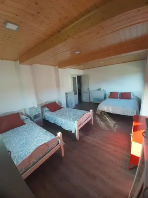 two beds in a room with wooden floors at A Casa dos Vellos in Santa Irene