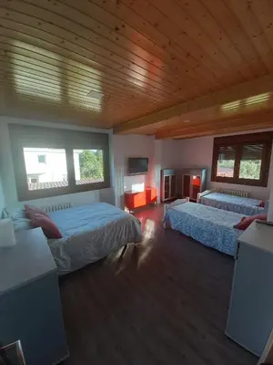 a bedroom with two beds and a wooden ceiling at A Casa dos Vellos in Santa Irene