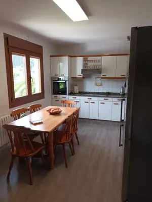 a kitchen with a table and chairs and a kitchen with white cabinets at A Casa dos Vellos in Santa Irene