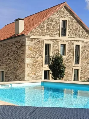 a house with a swimming pool in front of a building at Casa da Americana I in Boqueijón