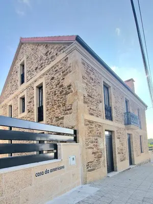 a brick building with a sign in front of it at Casa da Americana I in Boqueijón