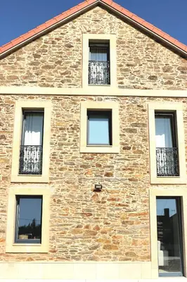 a brick building with windows on the side of it at Casa da Americana I in Boqueijón
