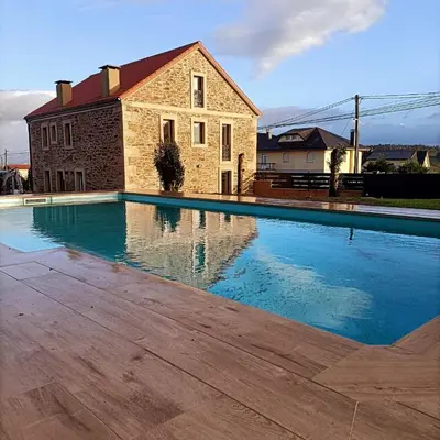 a large swimming pool in front of a building at Casa da Americana I in Boqueijón
