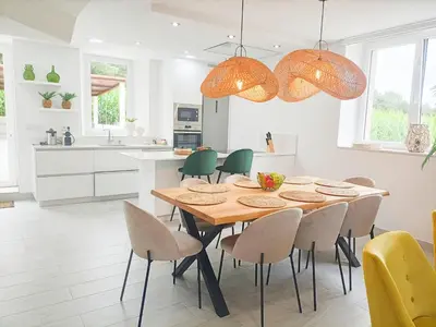 a kitchen and dining room with a wooden table and chairs at Casa da Americana II in Boqueijón