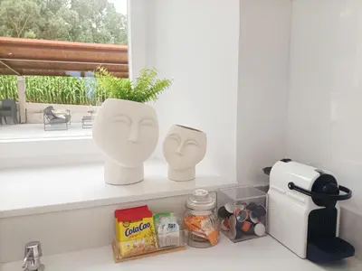 two masks sitting on a shelf next to a window at Casa da Americana II in Boqueijón