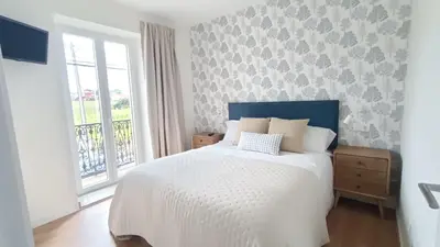 a bedroom with a white bed and a window at Casa da Americana II in Boqueijón
